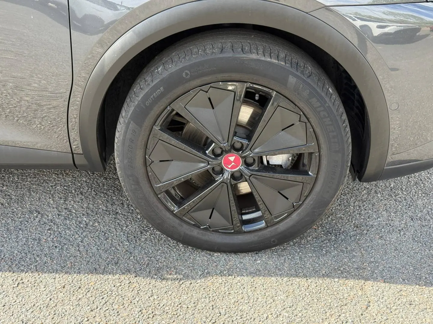 Gros plan sur la roue arrière droite gris titane du DS7 E-TENSE 2024 avec jante noire au design géométrique.