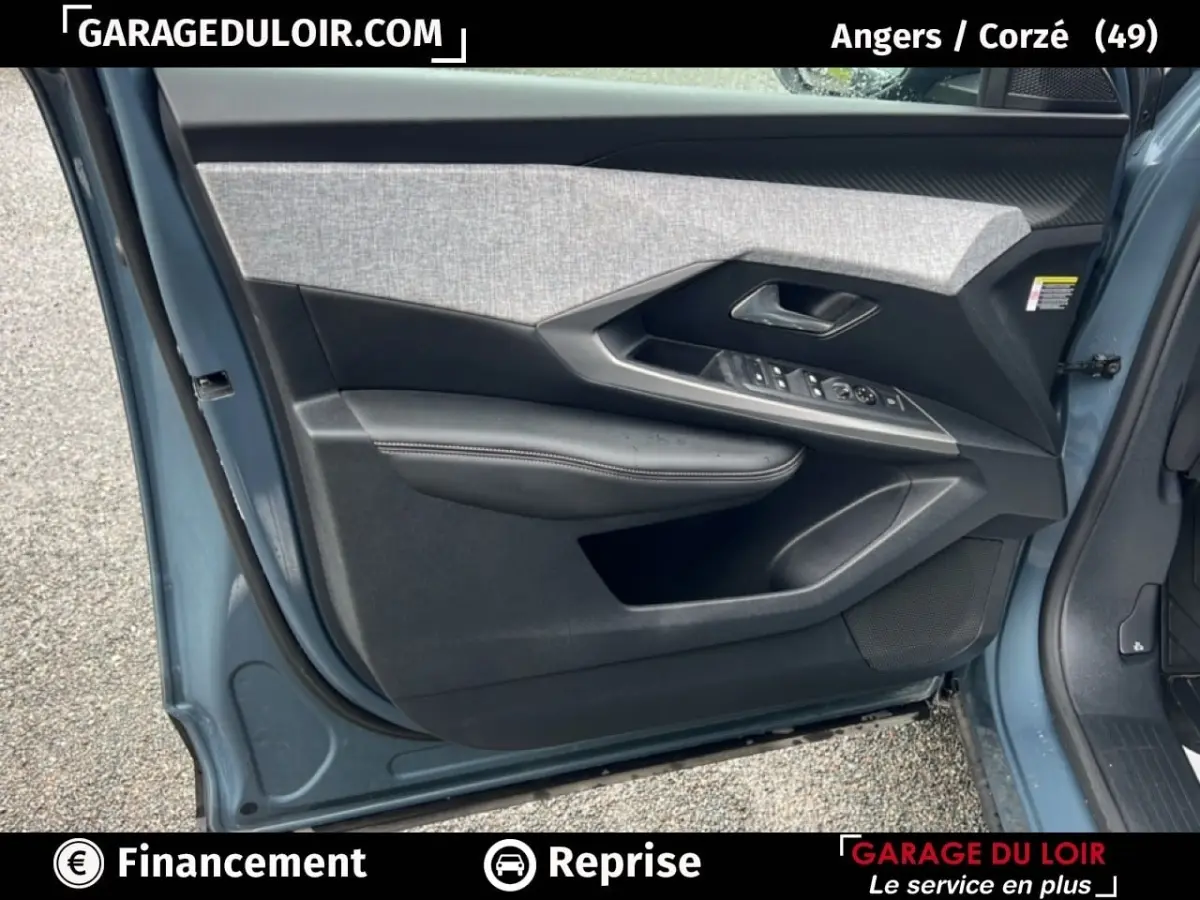 Porte avant gauche ouverte d’un Peugeot 5008 bleu 2024, montrant le panneau intérieur avec commandes et garniture grise.