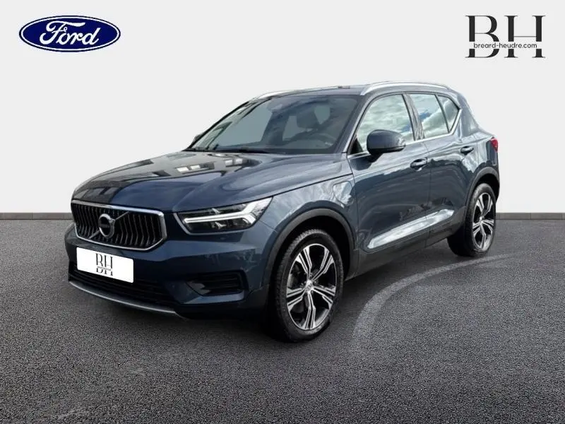 Volvo XC40 T4 Recharge bleu Denim en 3/4 avant droit, avec calandre chromée et jantes alliage distinctives.
