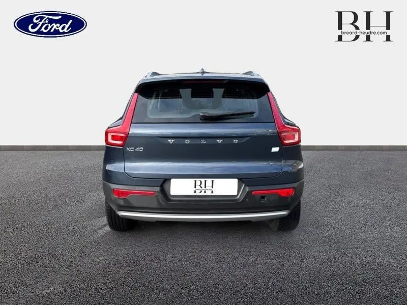 Vue arrière d'un Volvo XC40 bleu Denim, mettant en valeur ses feux arrière LED caractéristiques et son becquet.
