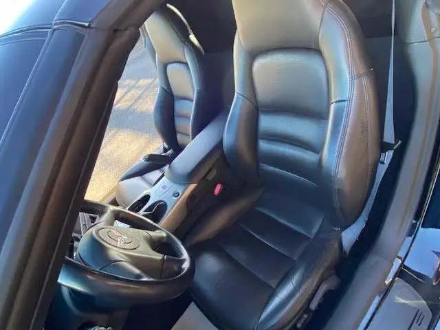 Vue intérieure côté conducteur de la Chevrolet Corvette C6 Targa 2005, sièges cuir noir et volant avec logo Corvette.
