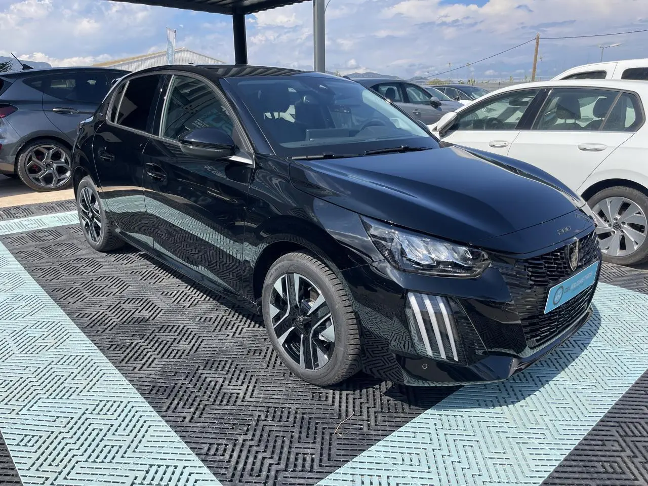 Peugeot 208 noir Onyx vue 3/4 avant droit, avec feux LED 3 griffes et jantes alliage diamantées biton.