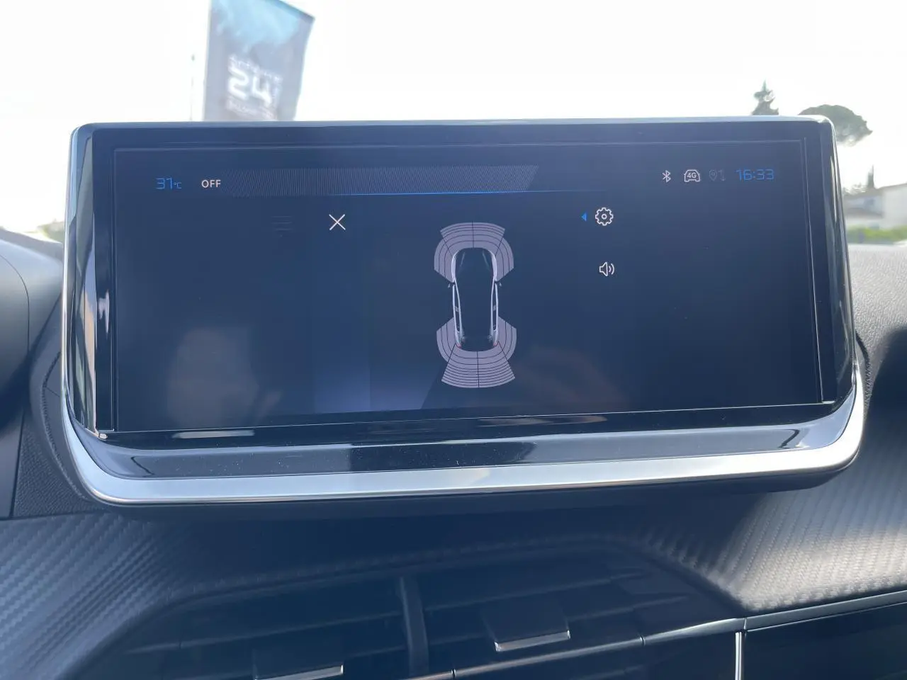 Écran tactile 10 pouces affichant l'aide au stationnement arrière dans le tableau de bord d'une Peugeot 208 noir Onyx.