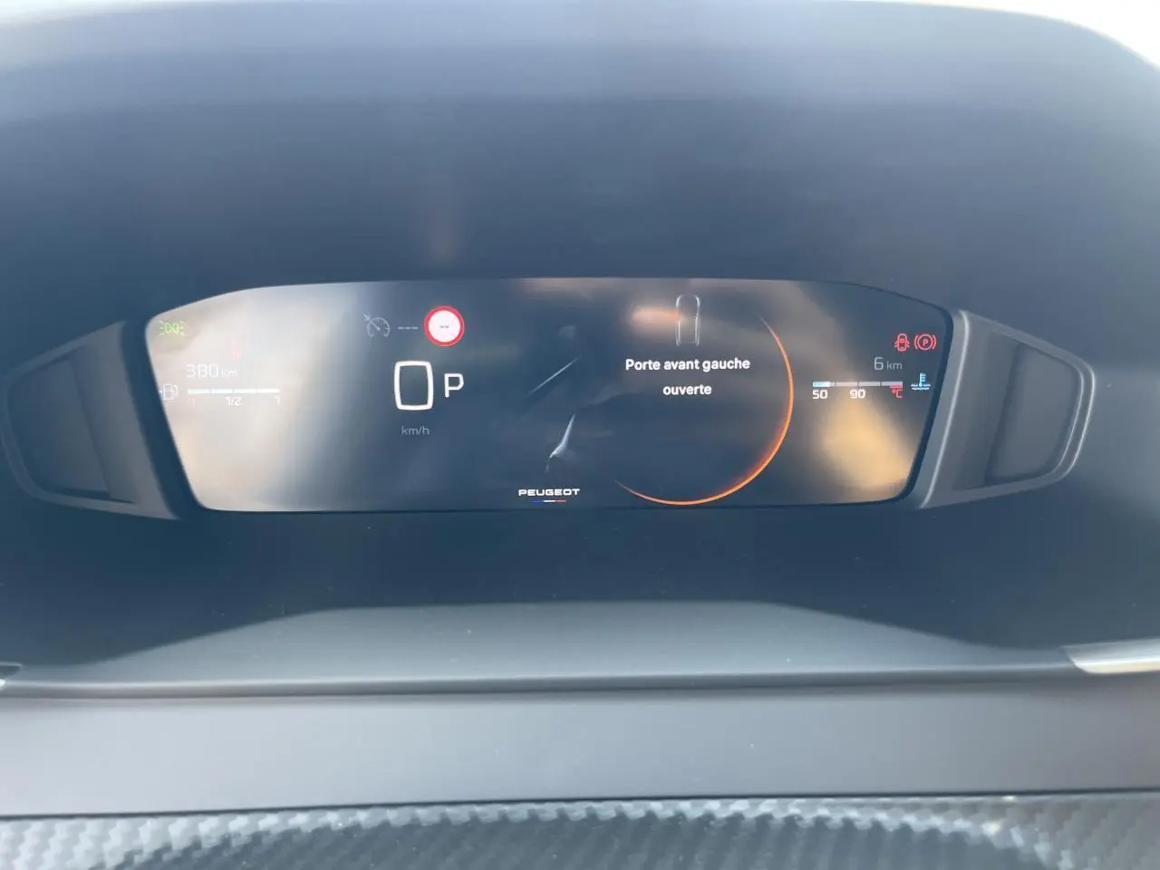 Tableau de bord numérique Peugeot 208 2024 affichant porte avant gauche ouverte et indicateurs de vitesse et carburant.