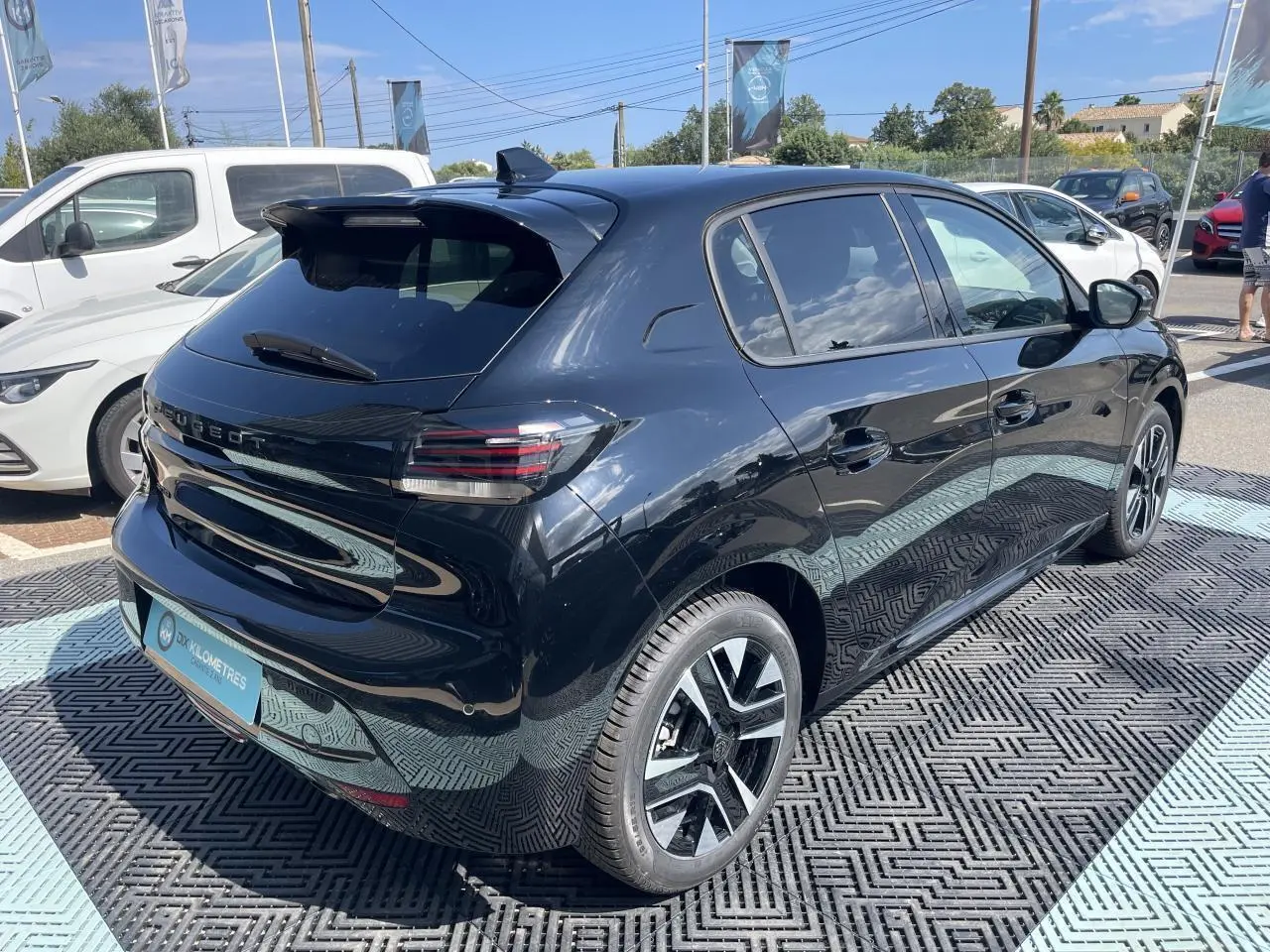 Peugeot 208 noir Onyx vue 3/4 arrière droit, jantes alliage diamantées et feux LED 3 griffes visibles.