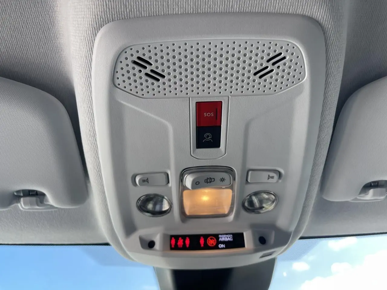 Plafonnier intérieur gris clair avec commandes d’éclairage et bouton SOS dans une Peugeot 208 noir Onyx 2024