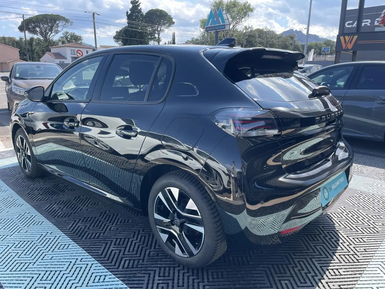 Peugeot 208 noir Onyx vue 3/4 arrière droit, jantes alliage biton et feux LED 3 griffes distinctifs visibles.