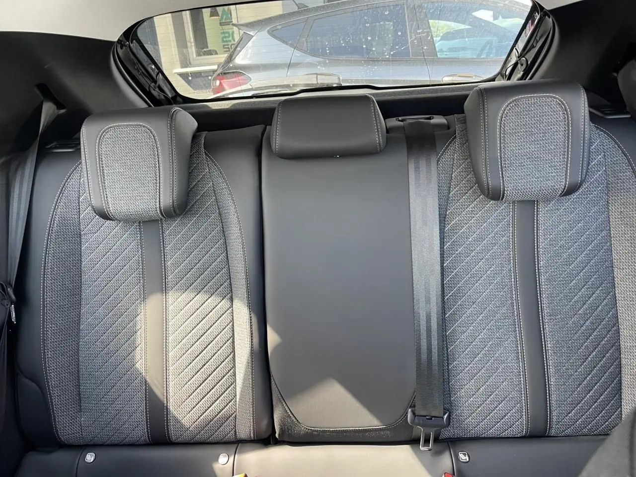 Vue rapprochée de la banquette arrière en tissu gris et TEP noir du Peugeot 208 New II 2024.