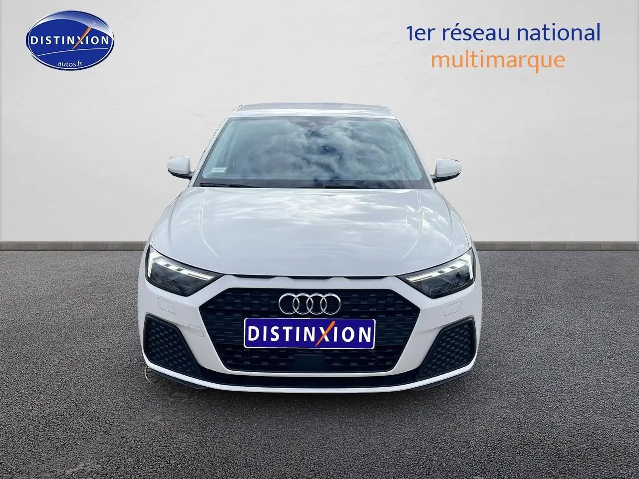 Vue de face d'une Audi A1 Sportback blanche 2022 avec calandre noire et phares LED allumés.