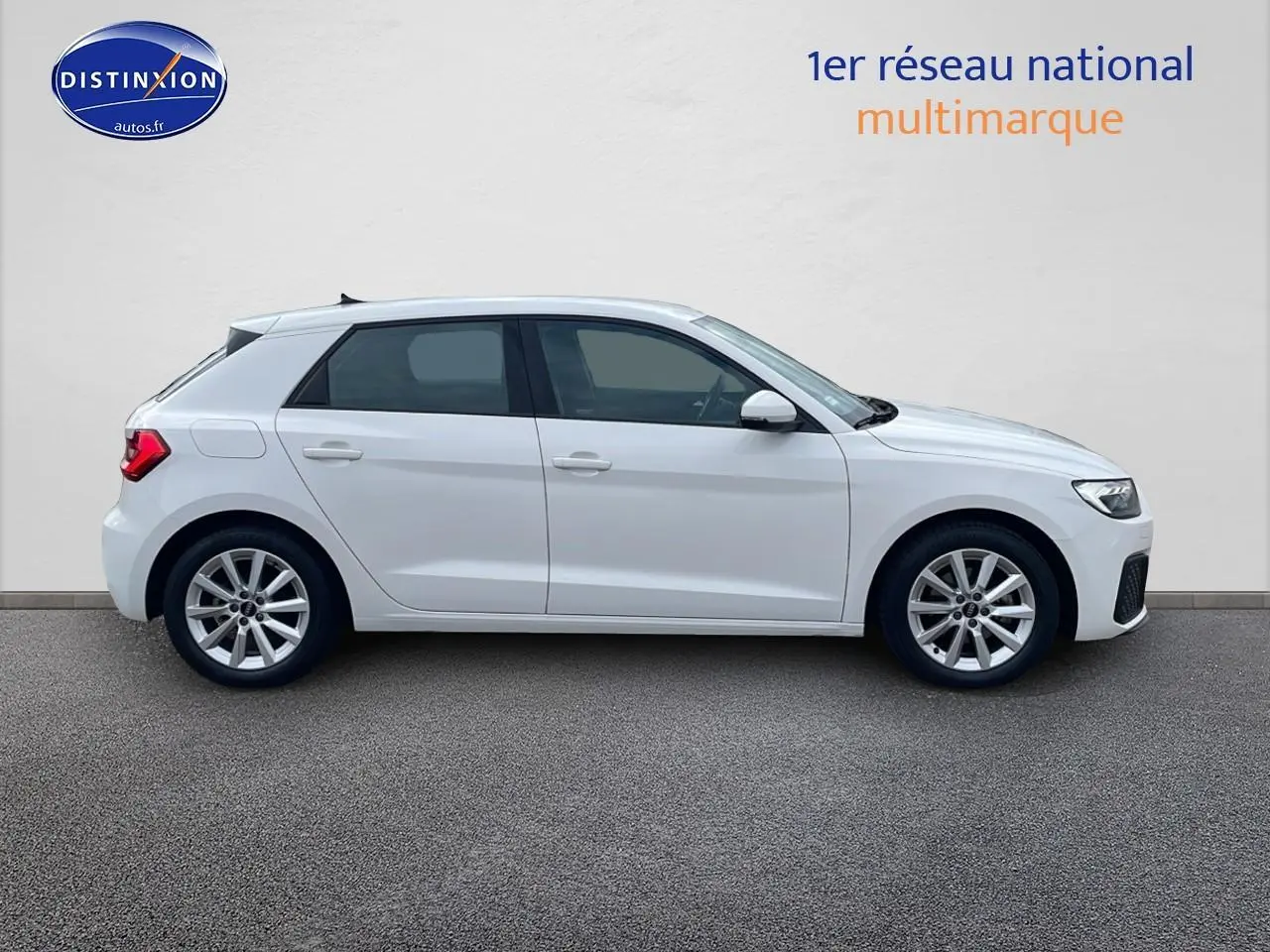 Profil latéral droit d'une Audi A1 Sportback blanche de 2022 avec jantes alu 16 pouces sur fond neutre.