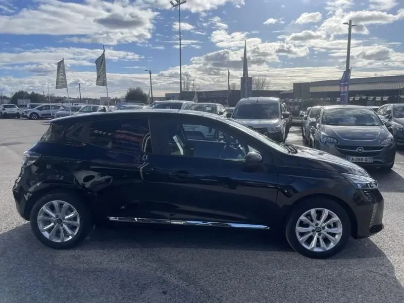 Profil côté gauche d'une Renault Clio V noire 2025, version 1.5 DCI 100 Evolution, sur un parking extérieur.