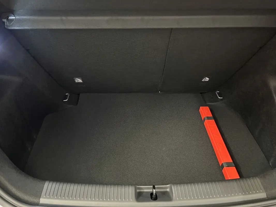 Vue plongeante sur le coffre noir de la MG3 1.5 HYBRID+ 195 LUXURY avec un triangle de signalisation rouge fixé sur le côté droit.