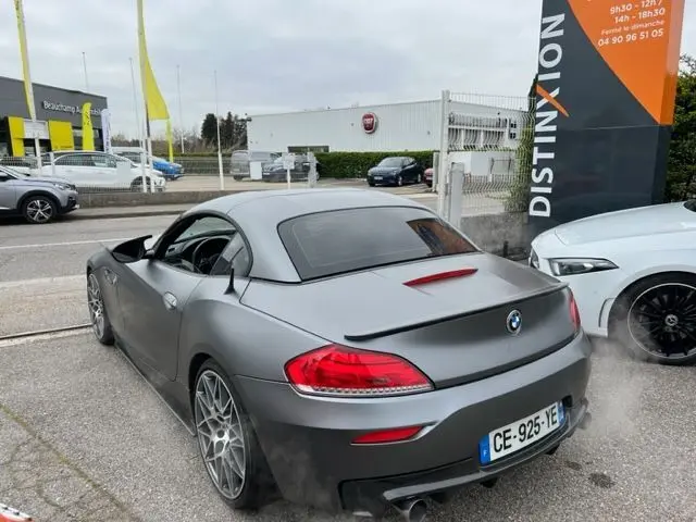 BMW Z4 Roadster grise vue 3/4 arrière avec toit rigide, jantes M Sport et double sortie d'échappement visible
