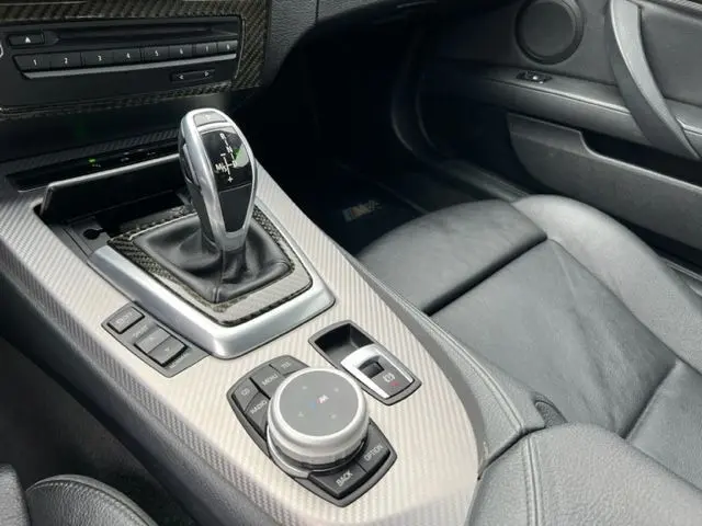 Gros plan sur la console centrale grise en fibre de carbone de la BMW Z4 Roadster 2012 avec levier de boîte automatique et commandes M Sport.
