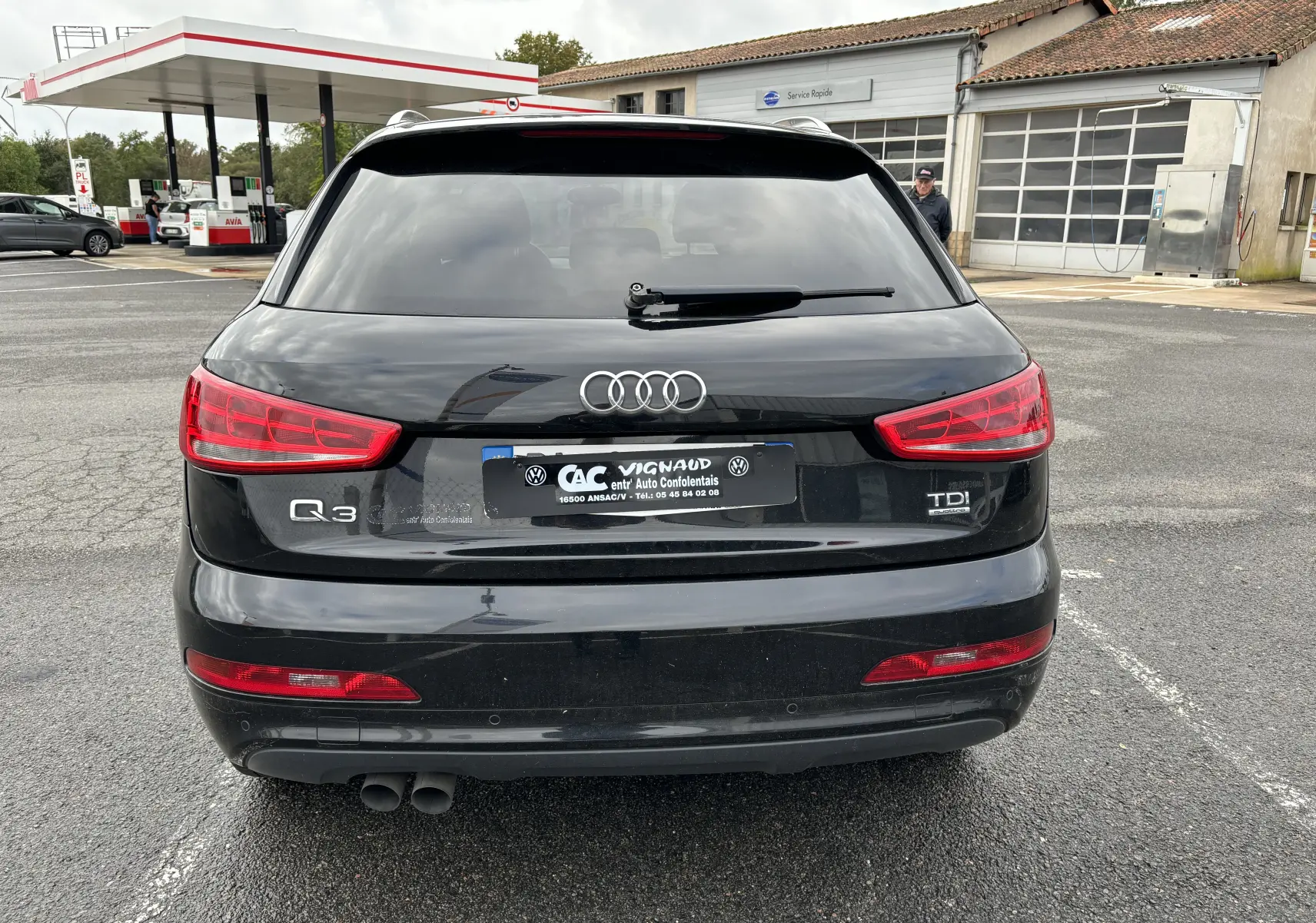 Vue arrière d'un Audi Q3 noir 2014 avec logo TDI et double sortie d'échappement visible sur parking.