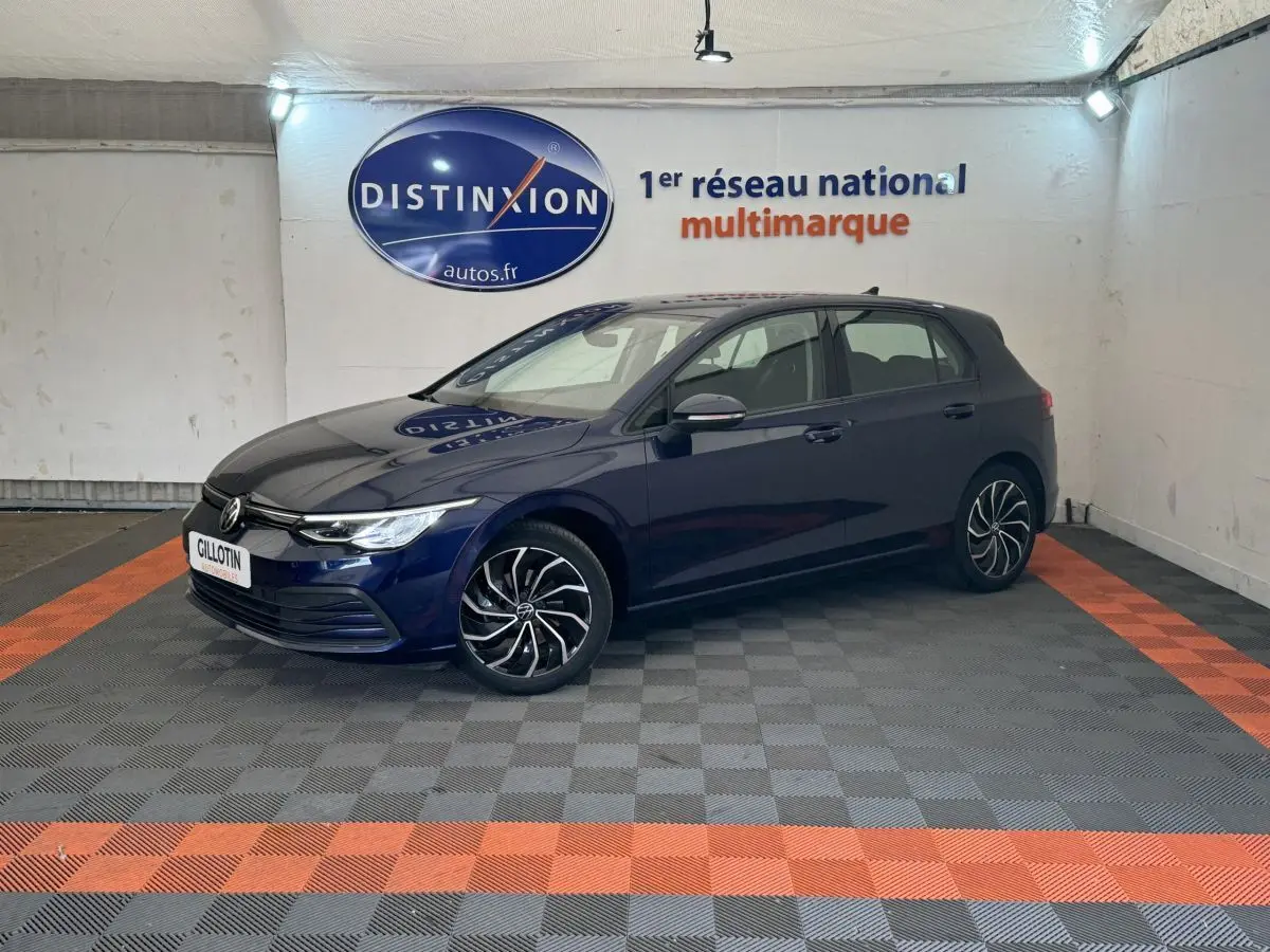 Volkswagen Golf bleu 2021 vue 3/4 avant droit, jantes alliage noires et phares LED allumés.