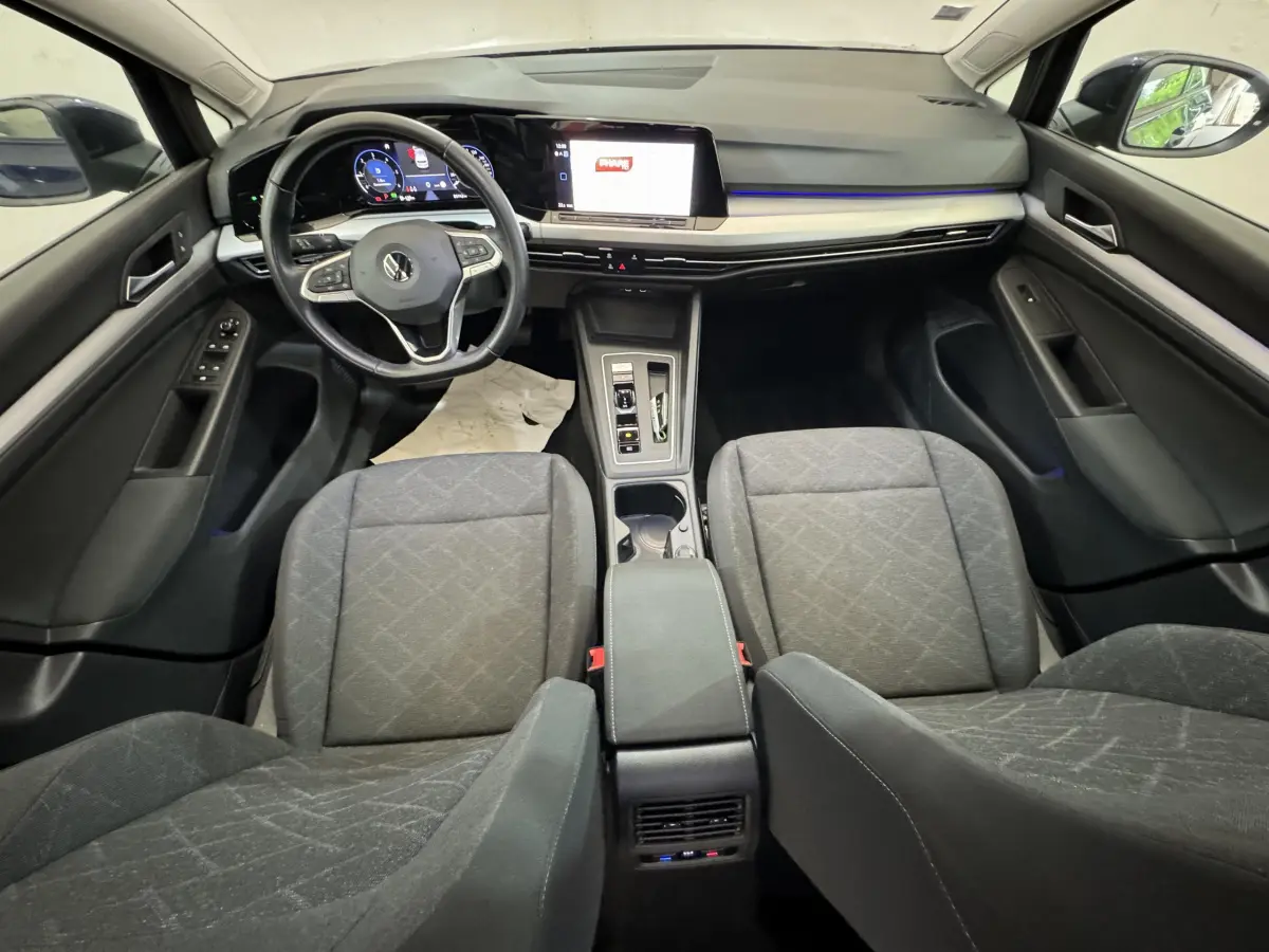 Vue intérieure avant de la Volkswagen Golf 2.0 TDI bleu, avec tableau de bord numérique et écran tactile central.