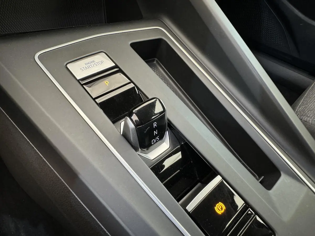 Gros plan sur la console centrale noire de la Volkswagen Golf 2021 avec levier de vitesse DSG et bouton start/stop.