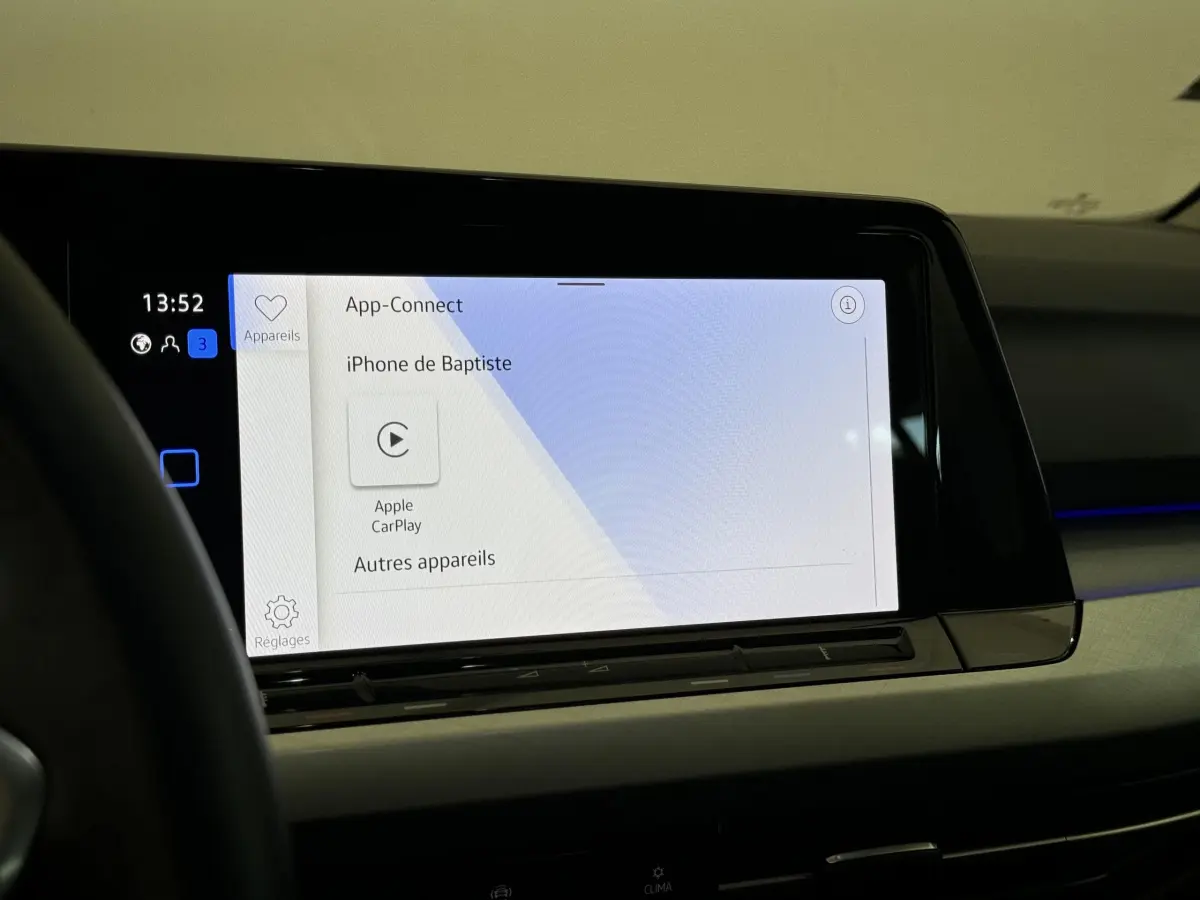 Écran tactile central affichant Apple CarPlay dans l'habitacle de la Volkswagen Golf bleu, vue intérieure côté conducteur.