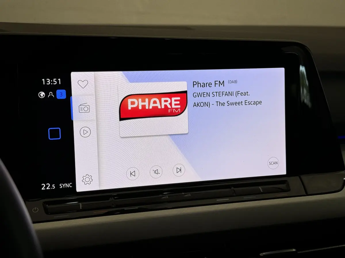 Écran tactile central affichant la radio Phare FM dans l'habitacle d'une Volkswagen Golf bleu 2021.