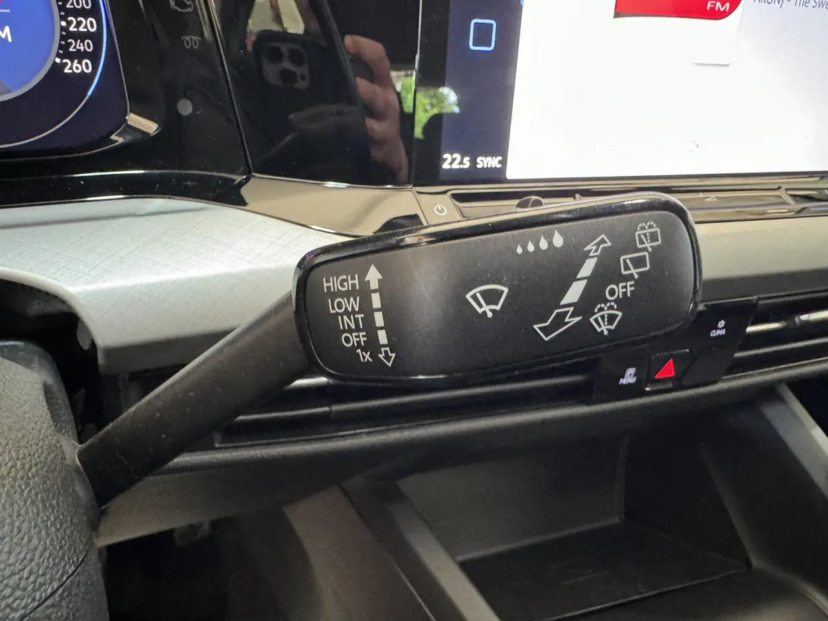 Gros plan sur la commande d'essuie-glace dans l'habitacle d'une Volkswagen Golf bleu 2021, avec tableau de bord numérique.