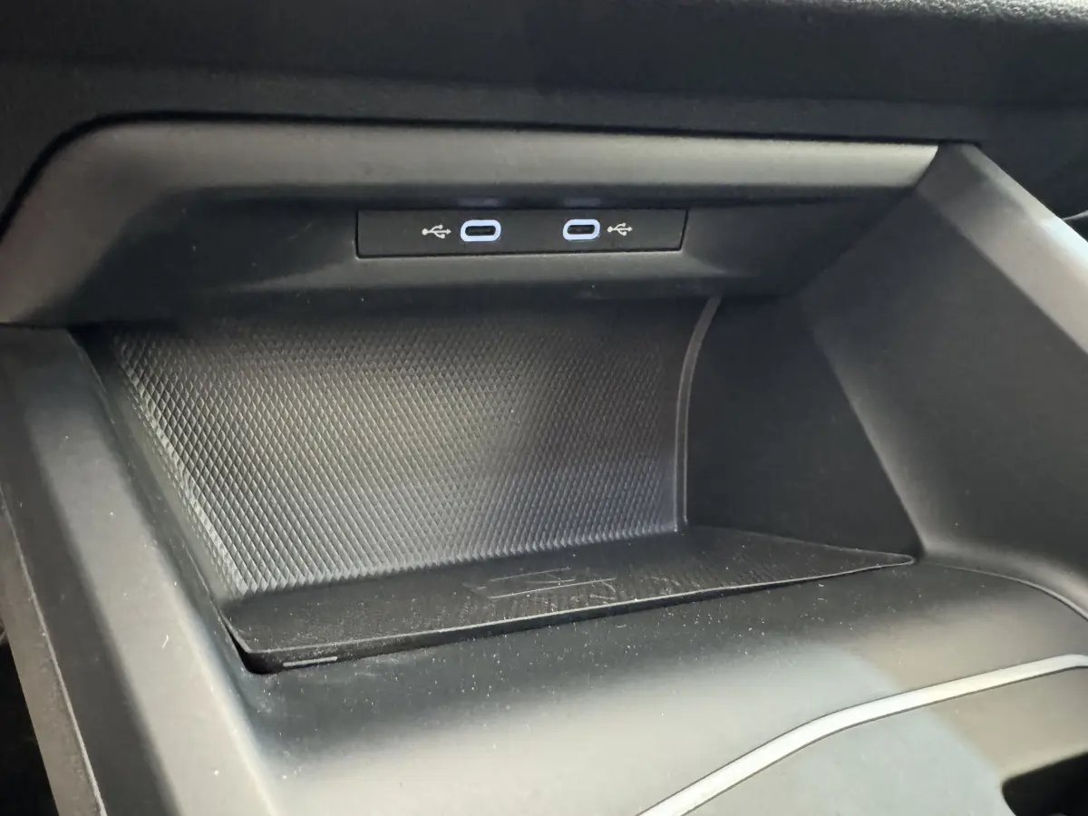 Gros plan sur la zone de chargement USB double dans l'habitacle noir d'une Volkswagen Golf 2.0 TDI 2021