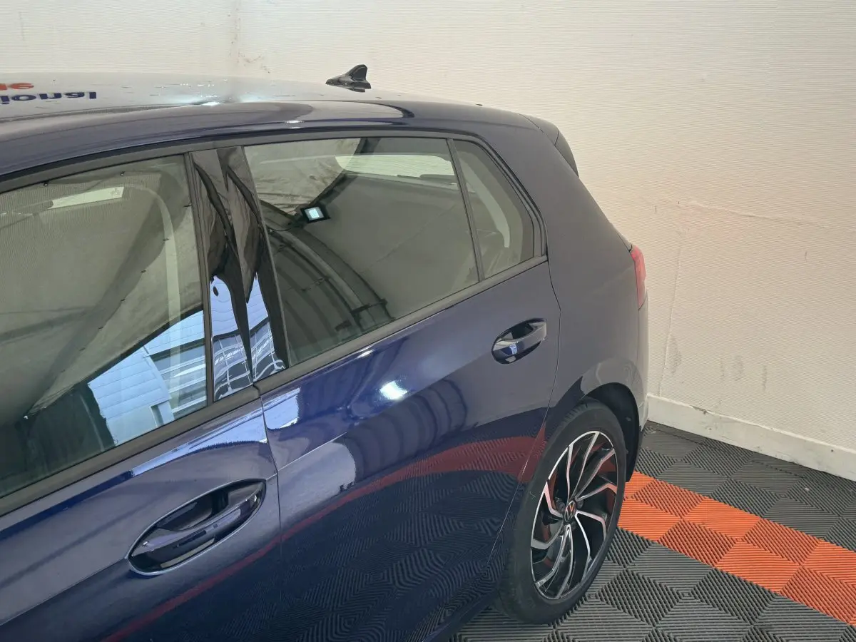 Vue latérale arrière droite d'une Volkswagen Golf 2.0 TDI bleu métallisé avec jantes alliage sport.