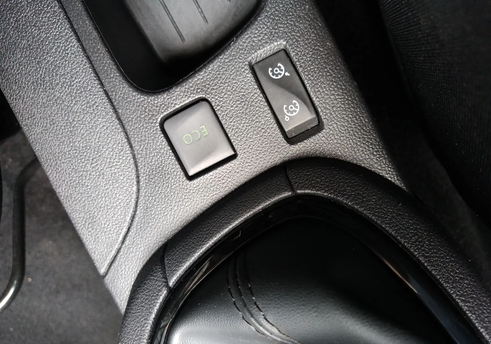 Gros plan sur les commandes ECO et régulateur de vitesse près du levier de vitesses d'une Renault Clio IV Société blanche.