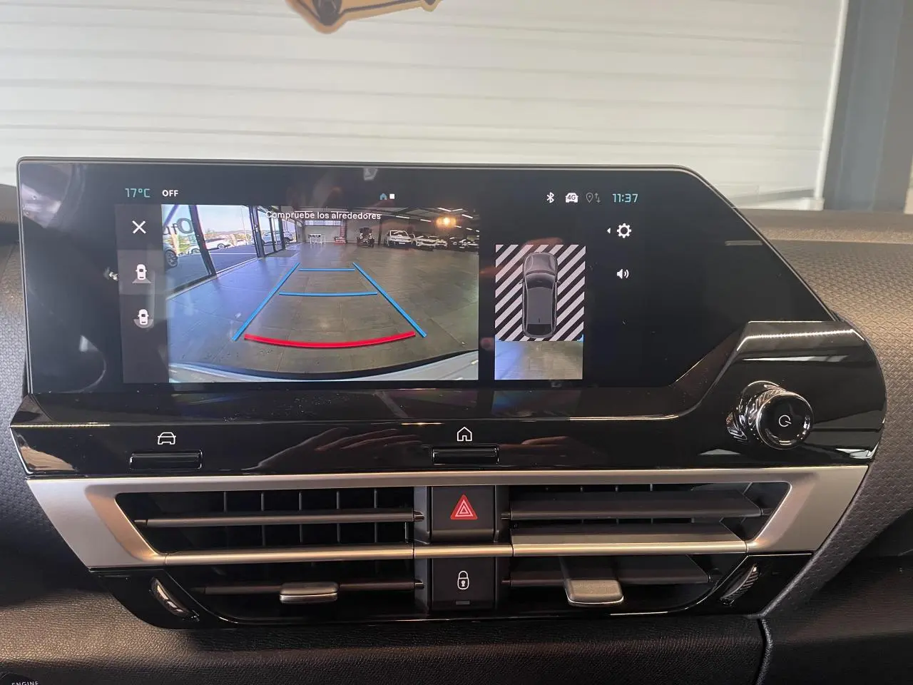 Vue rapprochée de l’écran central tactile affichant la caméra de recul dans l’habitacle d’une Citroën C4 blanche.