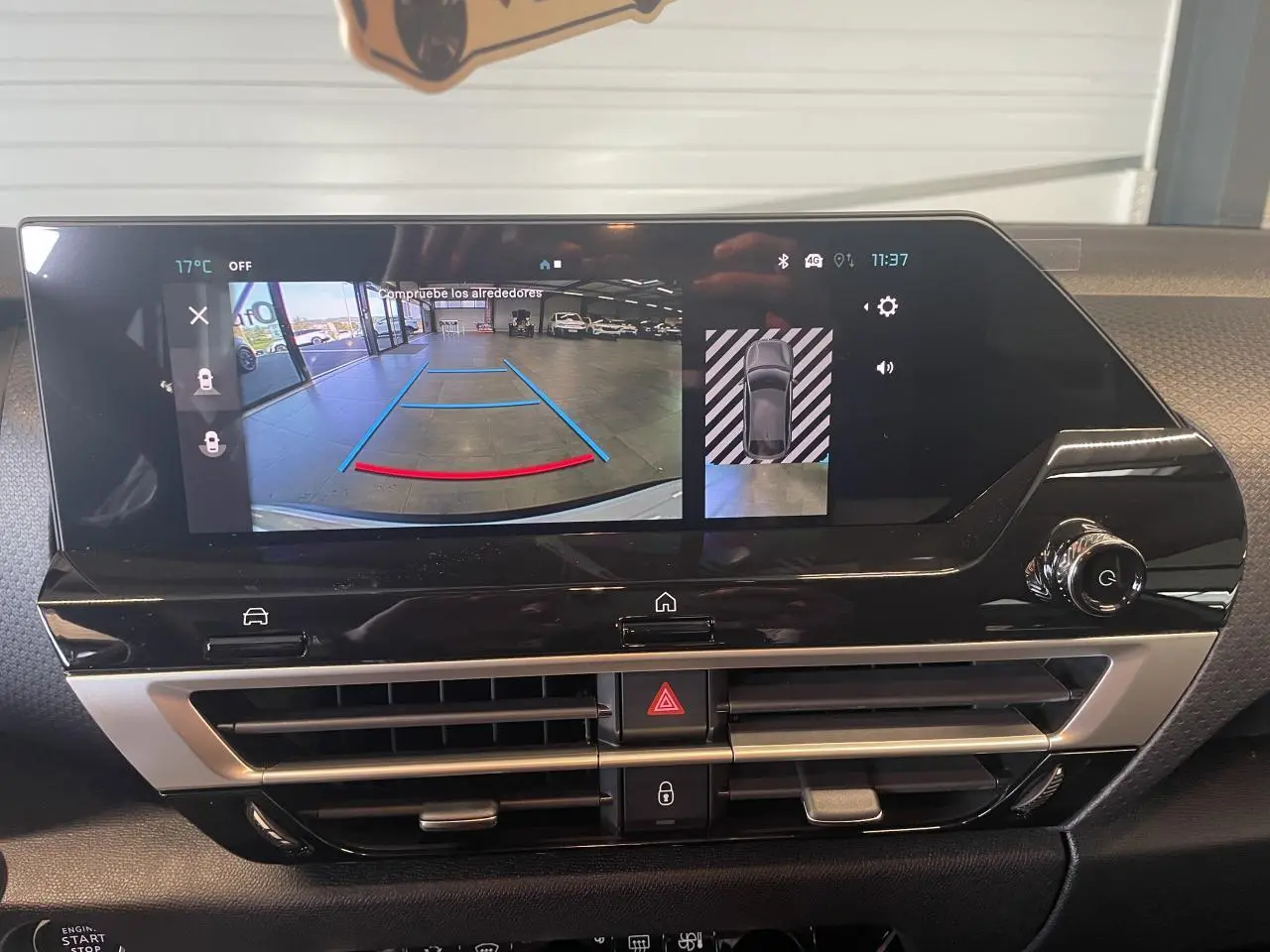 Écran central tactile de la Citroën C4 2025 blanc métallisé montrant la caméra de recul et l’aide au stationnement.