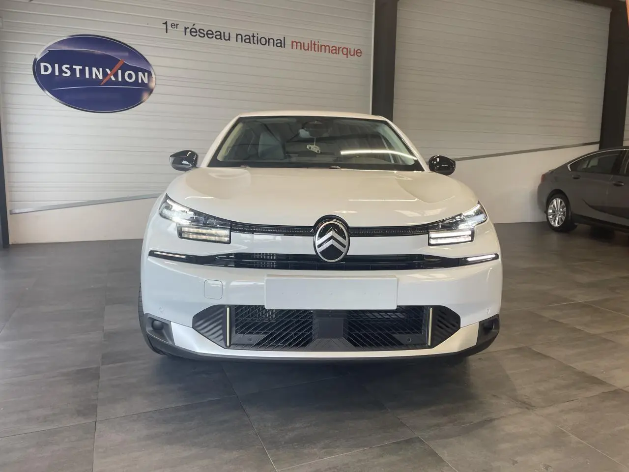 Vue avant d'une Citroën C4 blanche métallisée avec calandre noire et signature lumineuse LED distinctive.