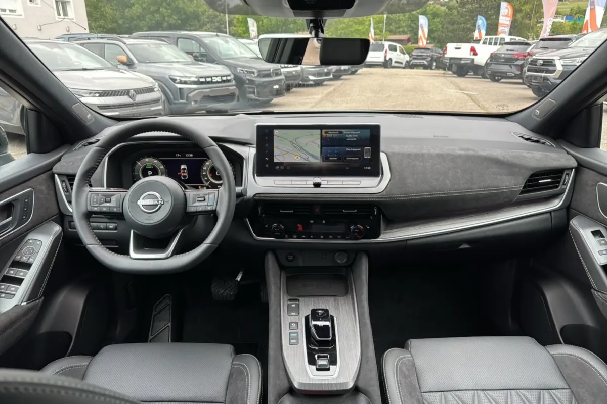 Vue intérieure avant du Nissan Qashqai E-POWER 205 Tekna Plus avec tableau de bord moderne et écran tactile central.