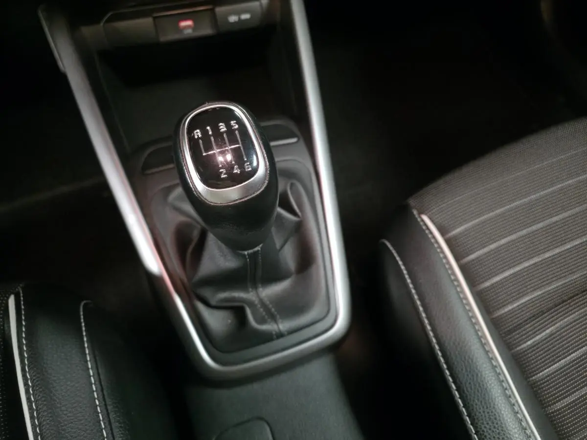 Levier de vitesses manuel noir avec surpiqûres blanches sur la console centrale d'une Kia Rio GT Line 2022.