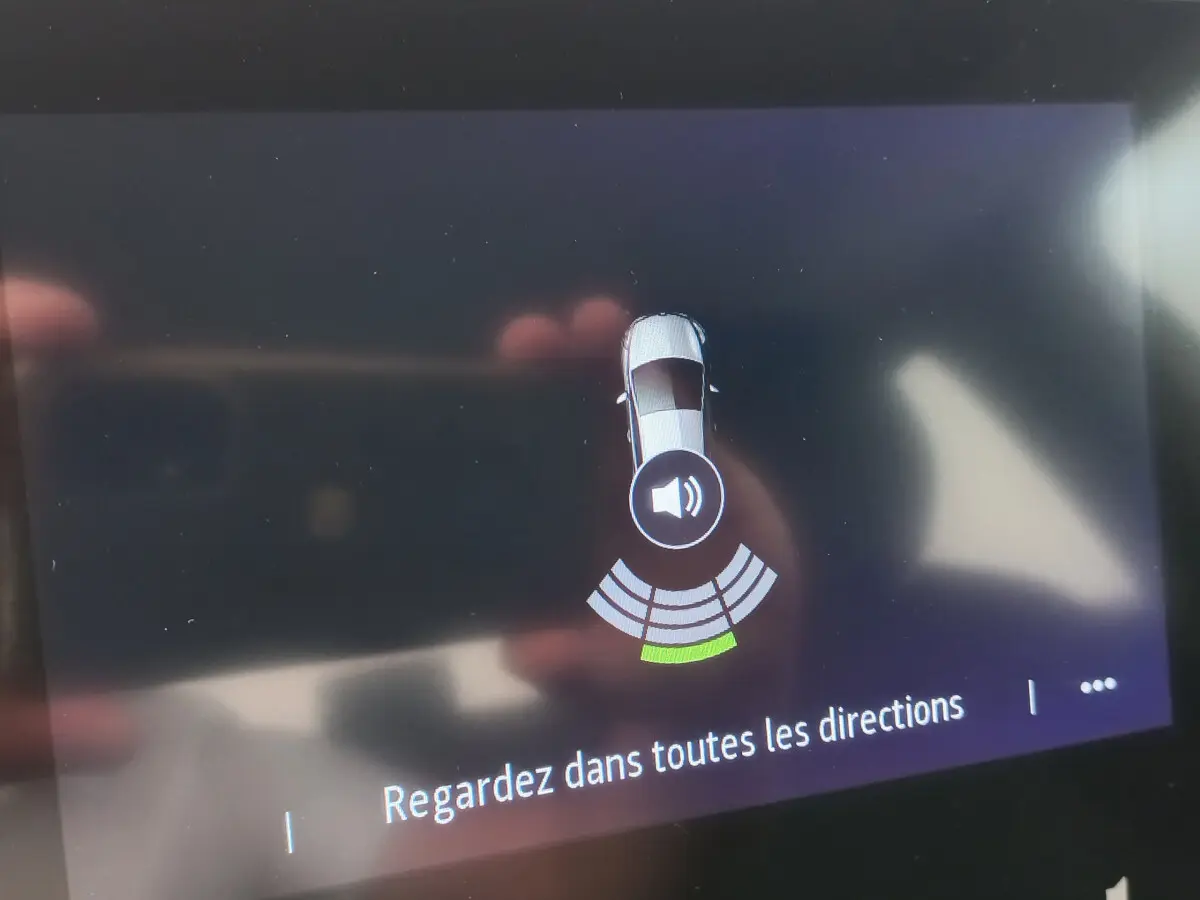 Écran tactile intérieur montrant l'alerte de capteurs de distance arrière de la Renault Clio Business blanche 2021.