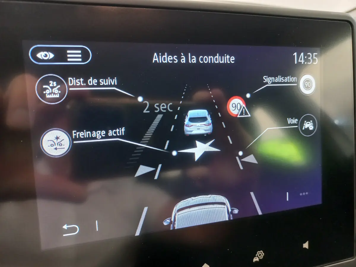 Écran tactile de la Renault Clio Business blanc montrant l'aide à la conduite avec freinage actif et suivi de distance.