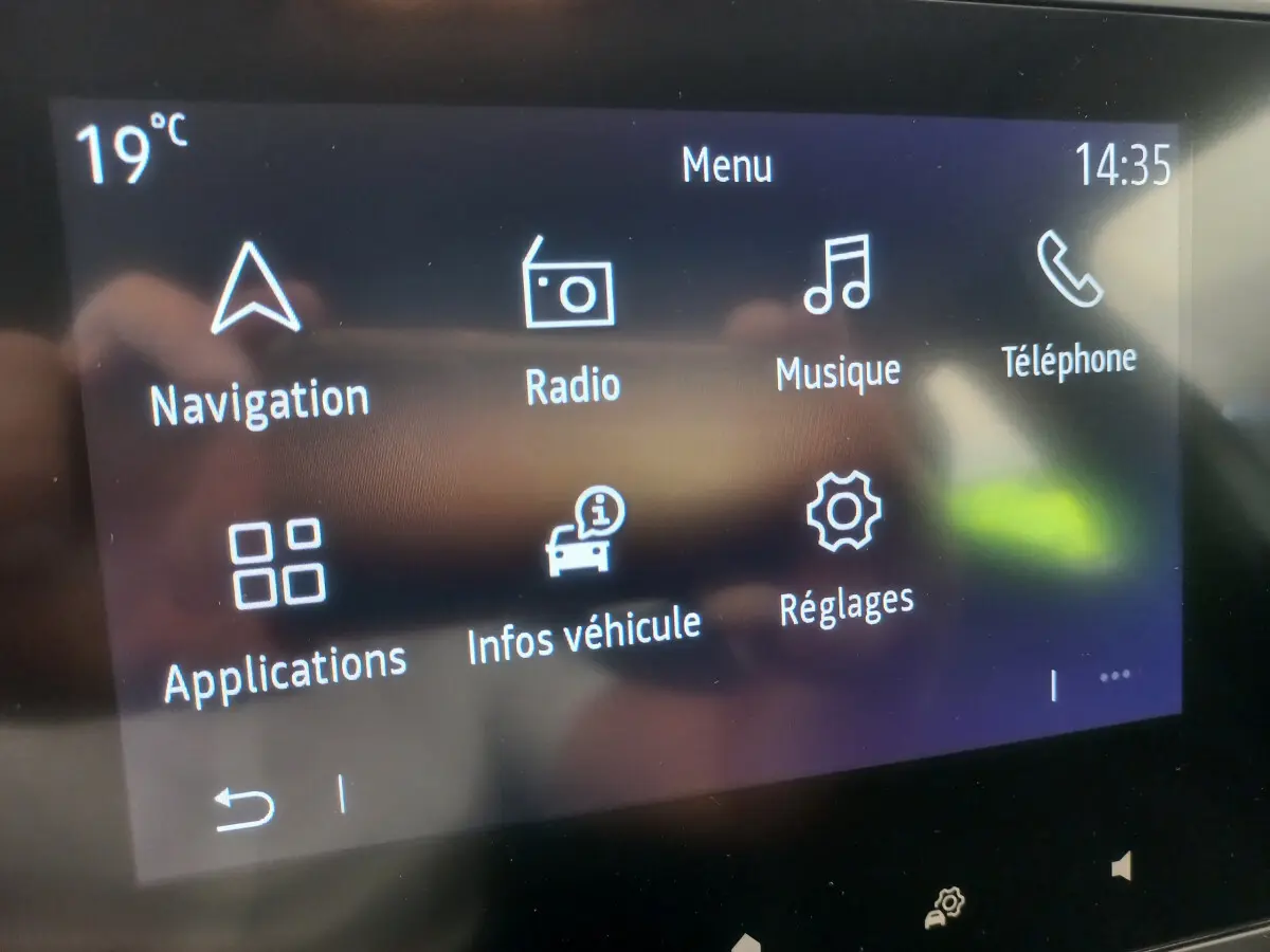 Écran tactile central de la Renault Clio Business blanc 2021 affichant le menu principal avec navigation et musique.