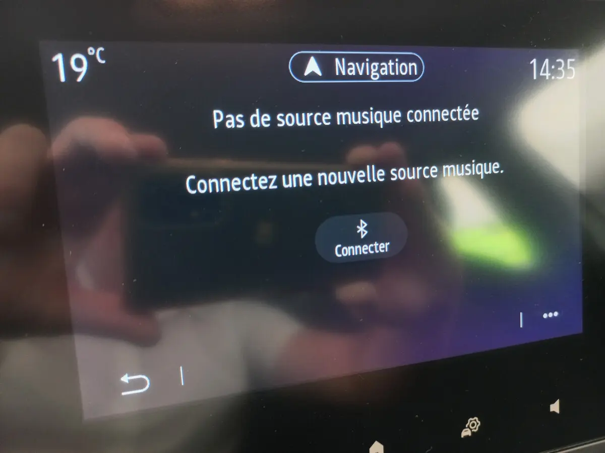 Écran tactile central de la Renault Clio Business blanc 2021 affichant un message de connexion Bluetooth pour la musique.