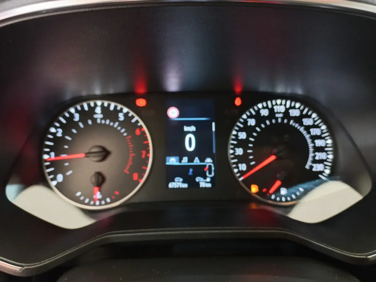 Gros plan sur le tableau de bord de la Renault Clio Business blanche, affichant compte-tours, vitesse et écran multifonctions.