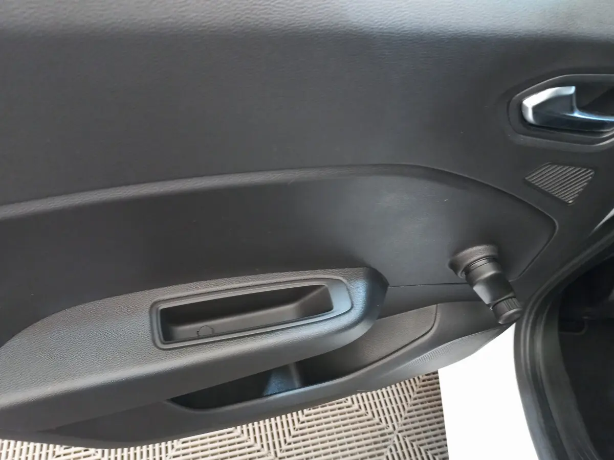 Détail de la porte intérieure côté droit de la Renault Clio Business blanche avec manivelle de vitre manuelle.