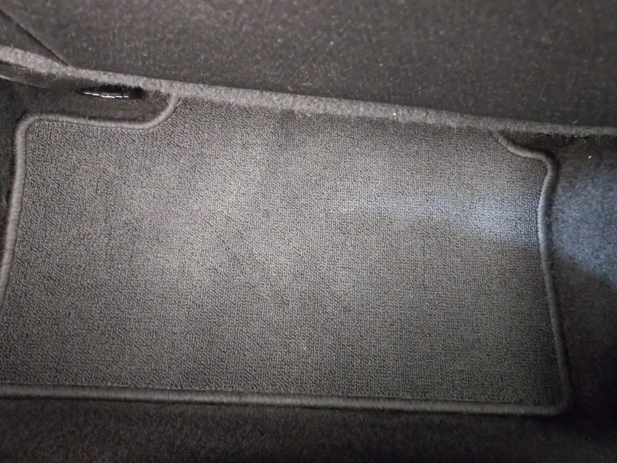 Tapis de sol noir en gros plan à l'intérieur d'une Renault Clio Business blanche 2021.