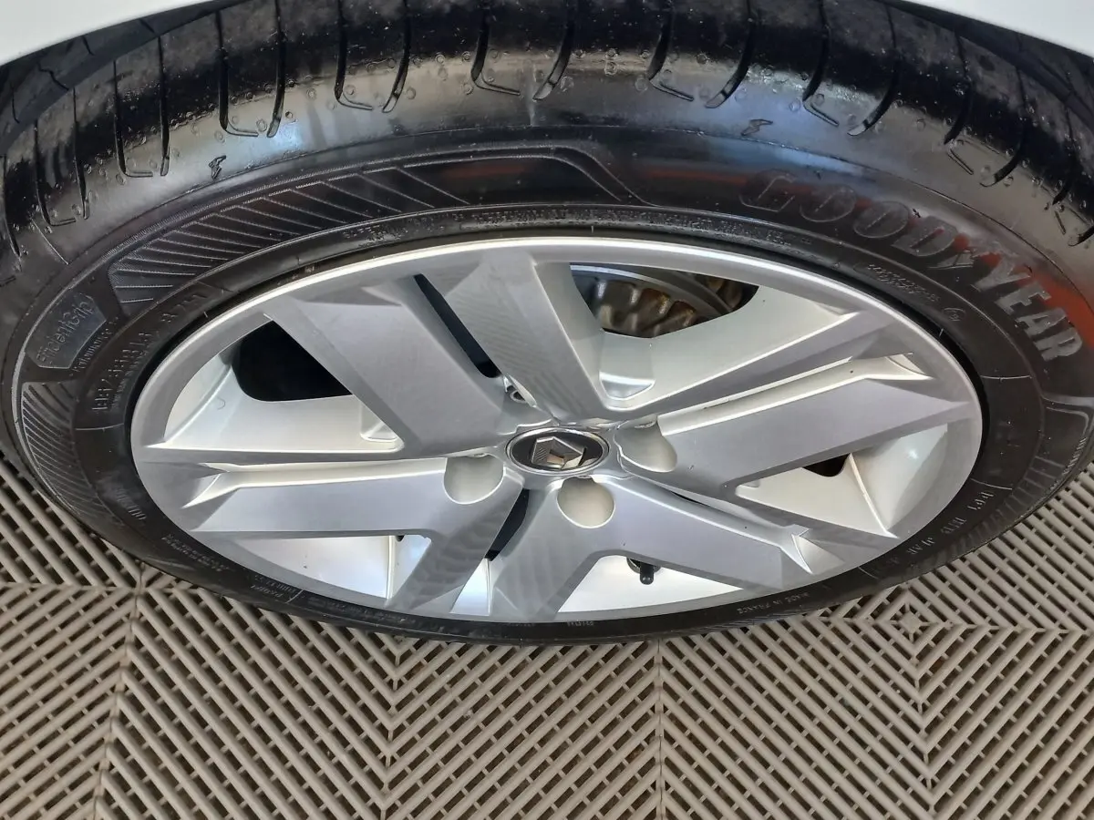 Gros plan sur la jante argentée et le pneu Goodyear d'une Renault Clio Business blanche, vue côté roue.