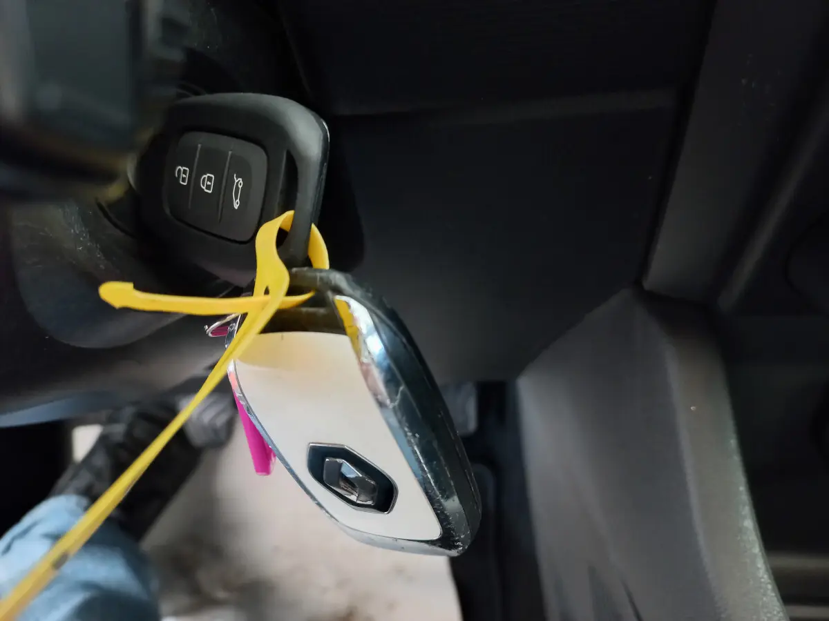 Gros plan sur la clé blanche et noire avec logo Renault accrochée au contacteur d'une Renault Clio Business 2021.