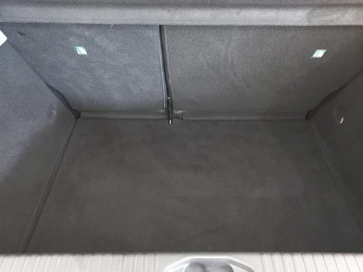 Coffre vide de Renault Clio Business blanc, vue plongeante sur l'espace de chargement avec banquette rabattue.