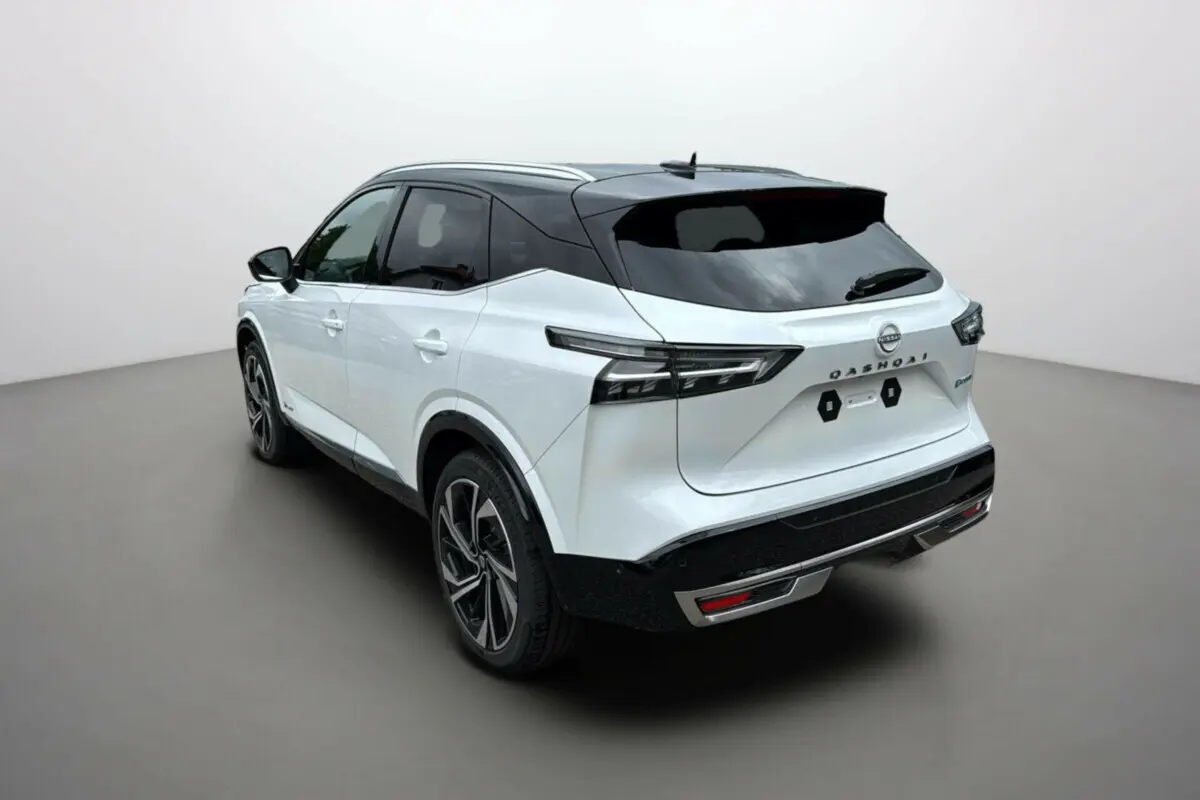 Vue 3/4 arrière droite du Nissan Qashqai blanc lunaire avec toit noir et jantes alu 20 pouces.
