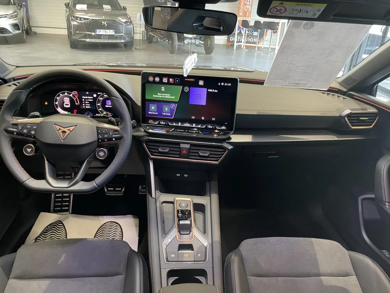 Intérieur CUPRA Leon 2026 vu de face, tableau de bord noir avec écran tactile central et volant multifonction.