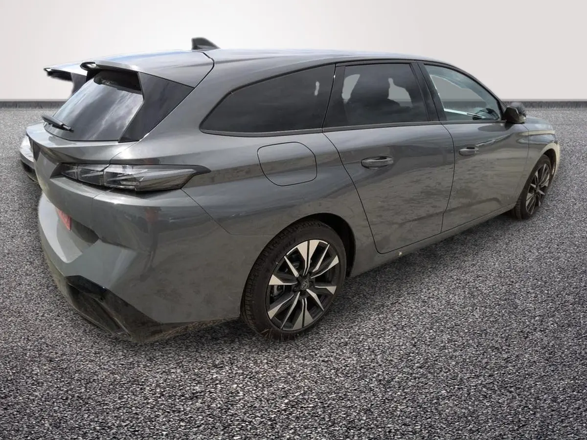 Peugeot 308 Hybrid gris foncé vue 3/4 arrière droit, avec jantes alliage et vitres teintées.