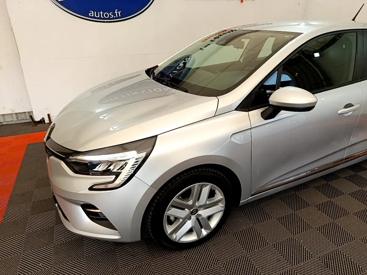 Renault Clio Business E-Tech hybride gris clair vue 3/4 avant droit, avec phares LED et jantes alliage visibles.