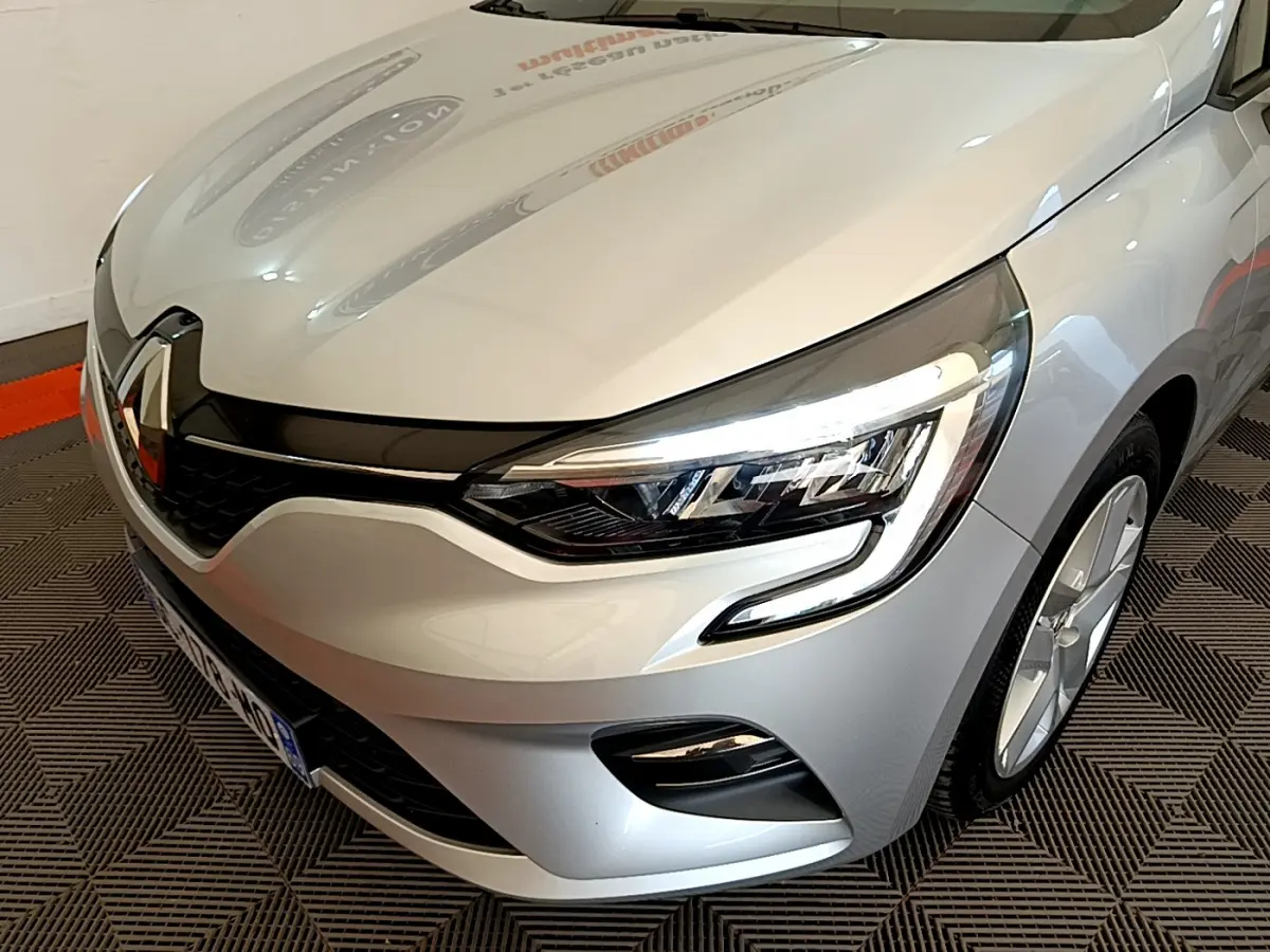 Vue 3/4 avant droit d'une Renault Clio Business E-Tech hybride 2021 gris clair avec phares LED et calandre noire.