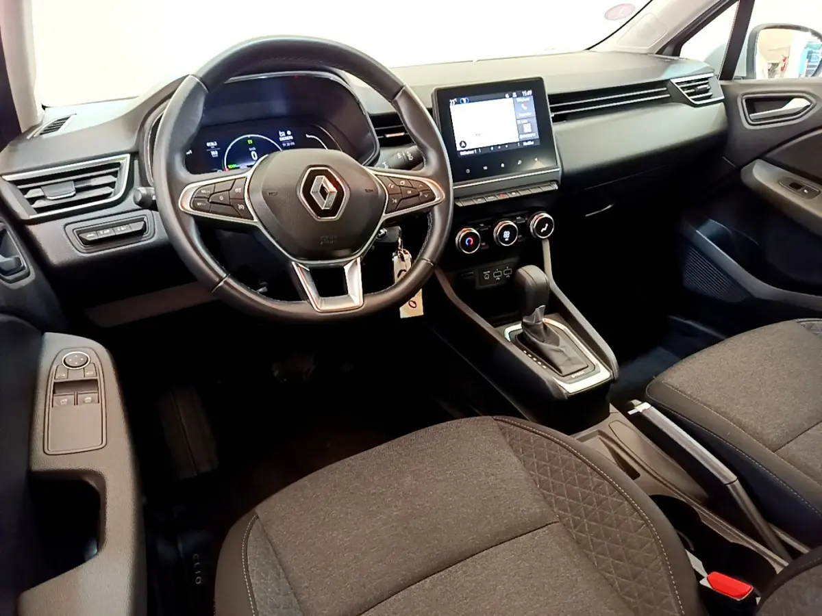 Vue intérieure avant droite de la Renault Clio Business E-Tech hybride 2021 avec volant multifonctions et écran tactile central.