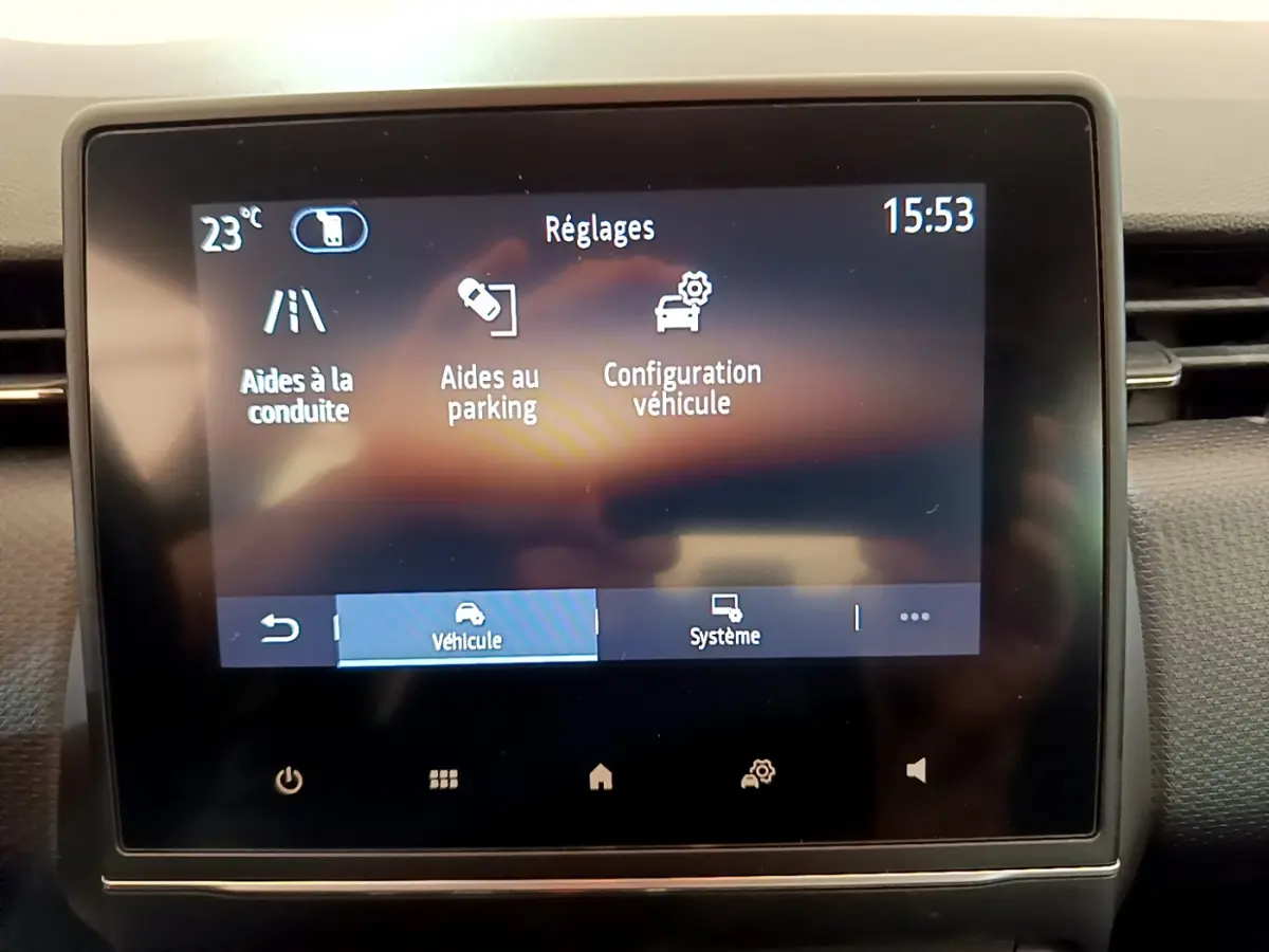 Écran tactile central de la Renault Clio Business E-Tech hybride 2021 affichant les réglages d'aides à la conduite et au parking.